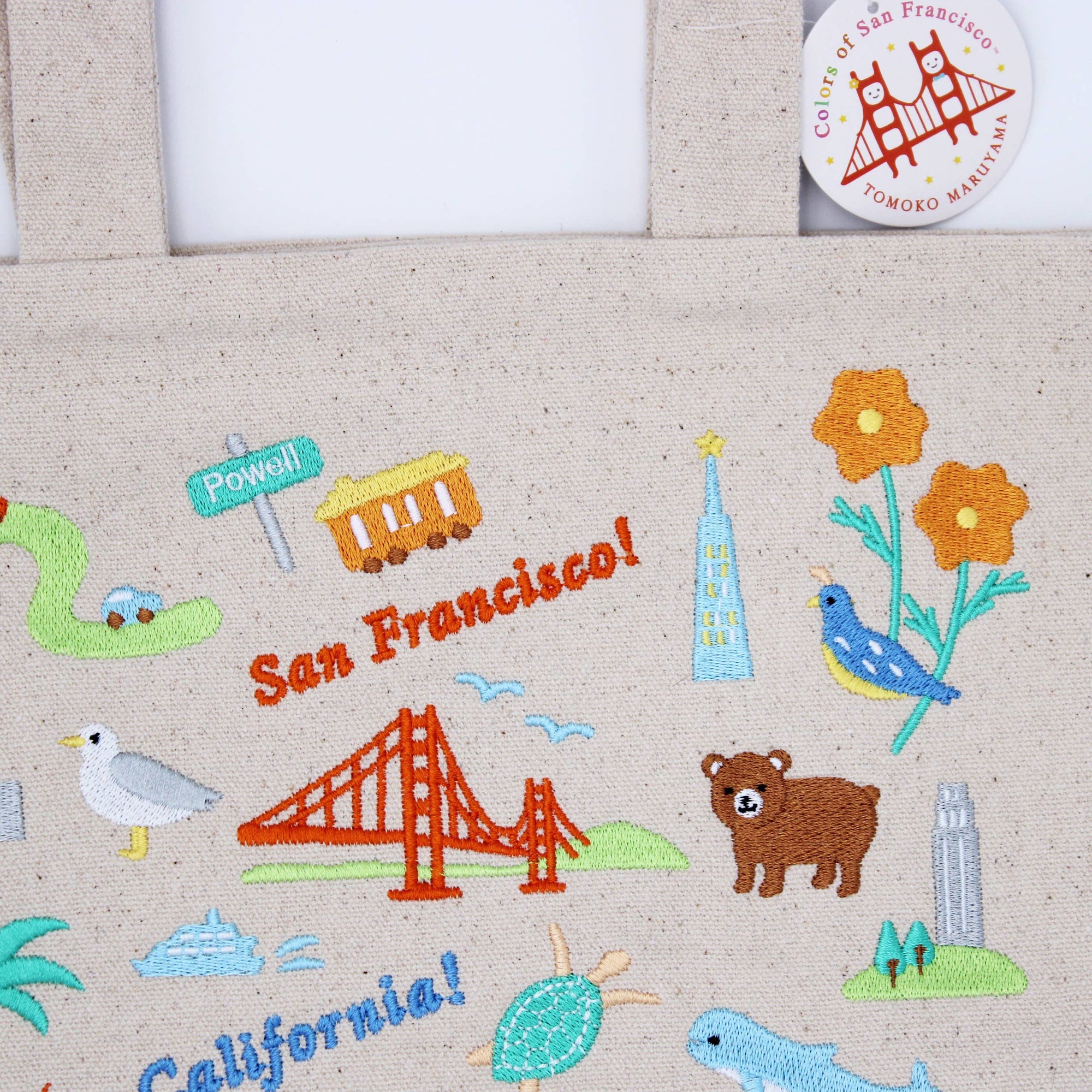 Embroidered design of San Francisco and California with iconic symbols on a fabric background.