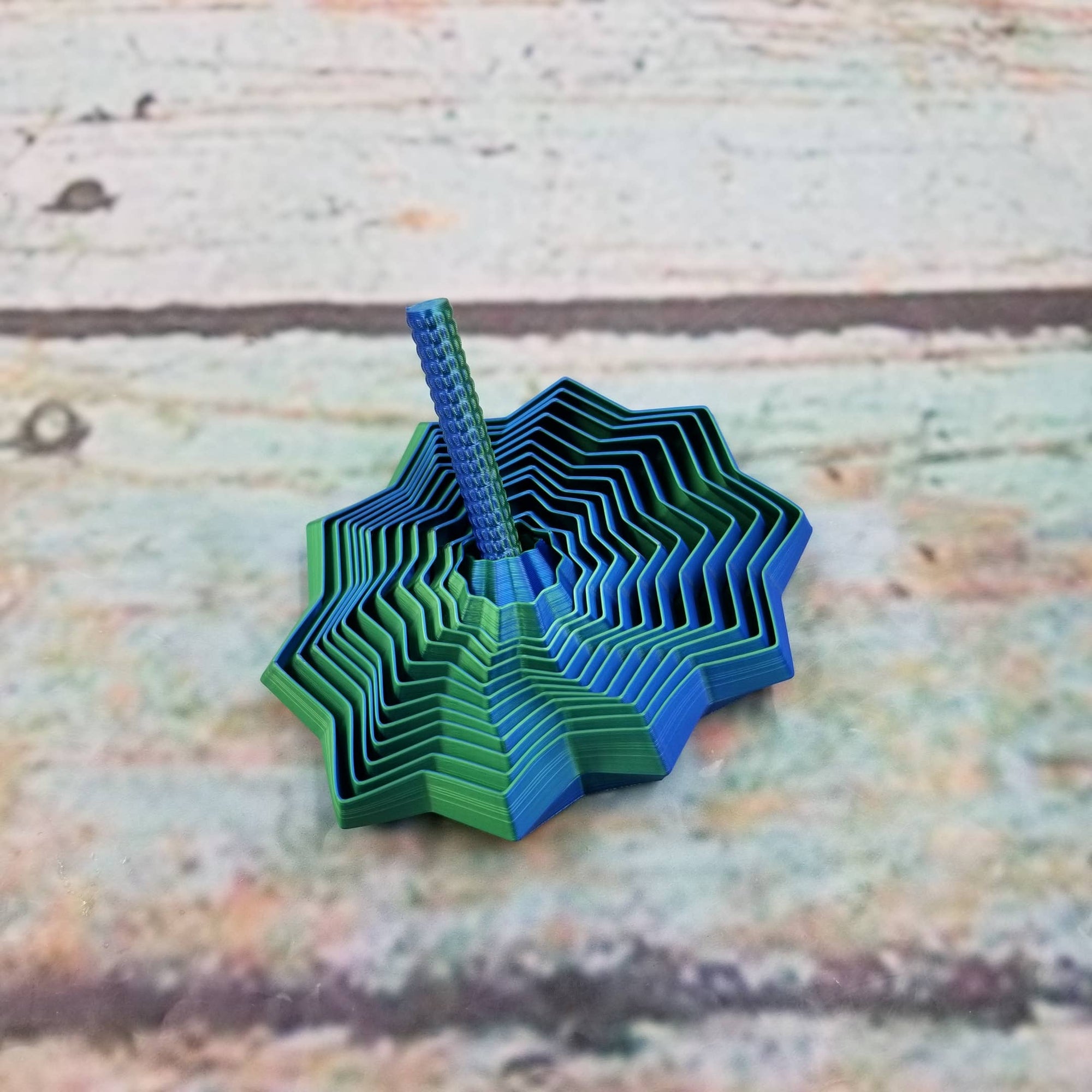 Blue and green paper sculpture on a textured wooden surface