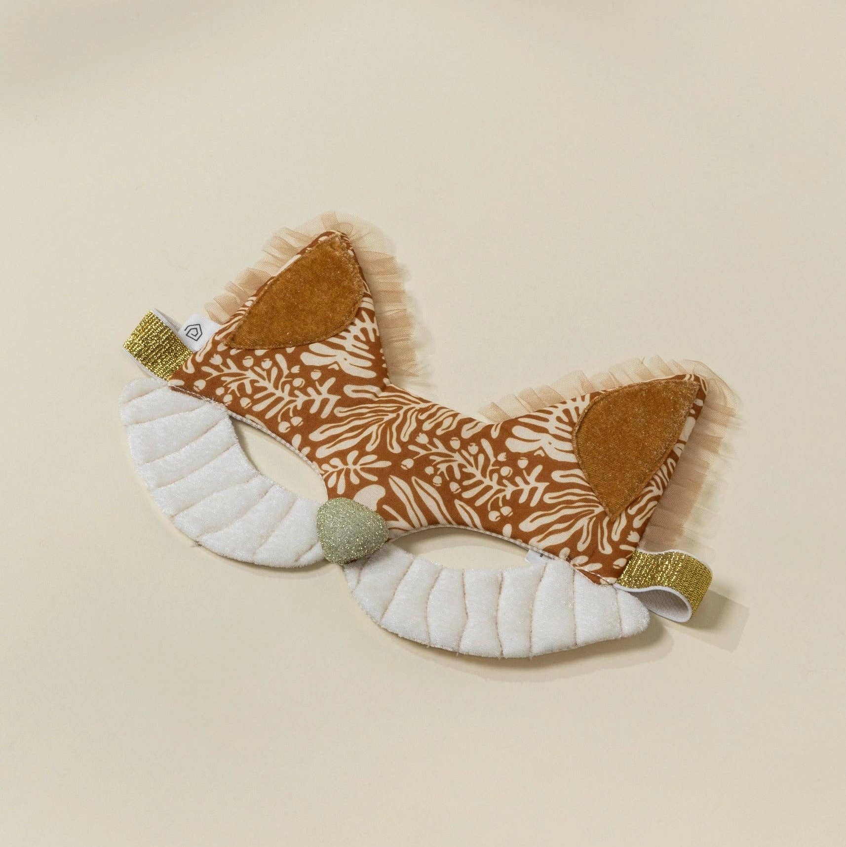 Fabric fox mask with patterned body and plain white belly on a beige background