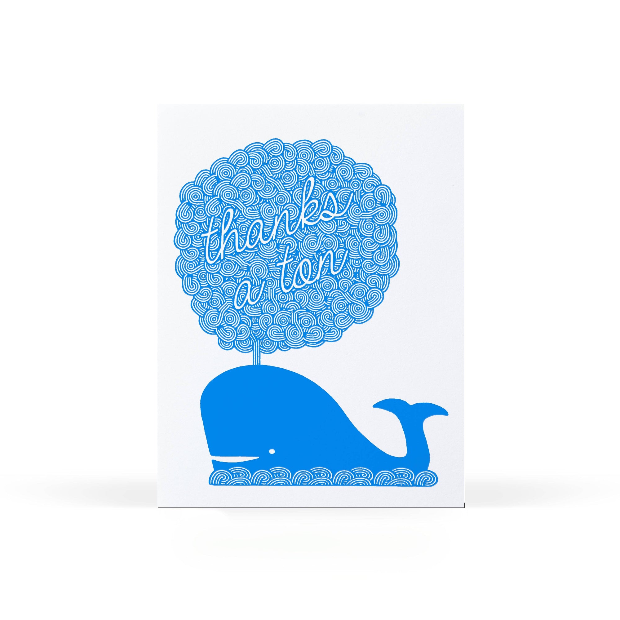 A white greeting card featuring a blue whale silhouette with a tree made of repeating blue circles, and the phrase 'thanks a ton' in white script across the upper part of the whale.