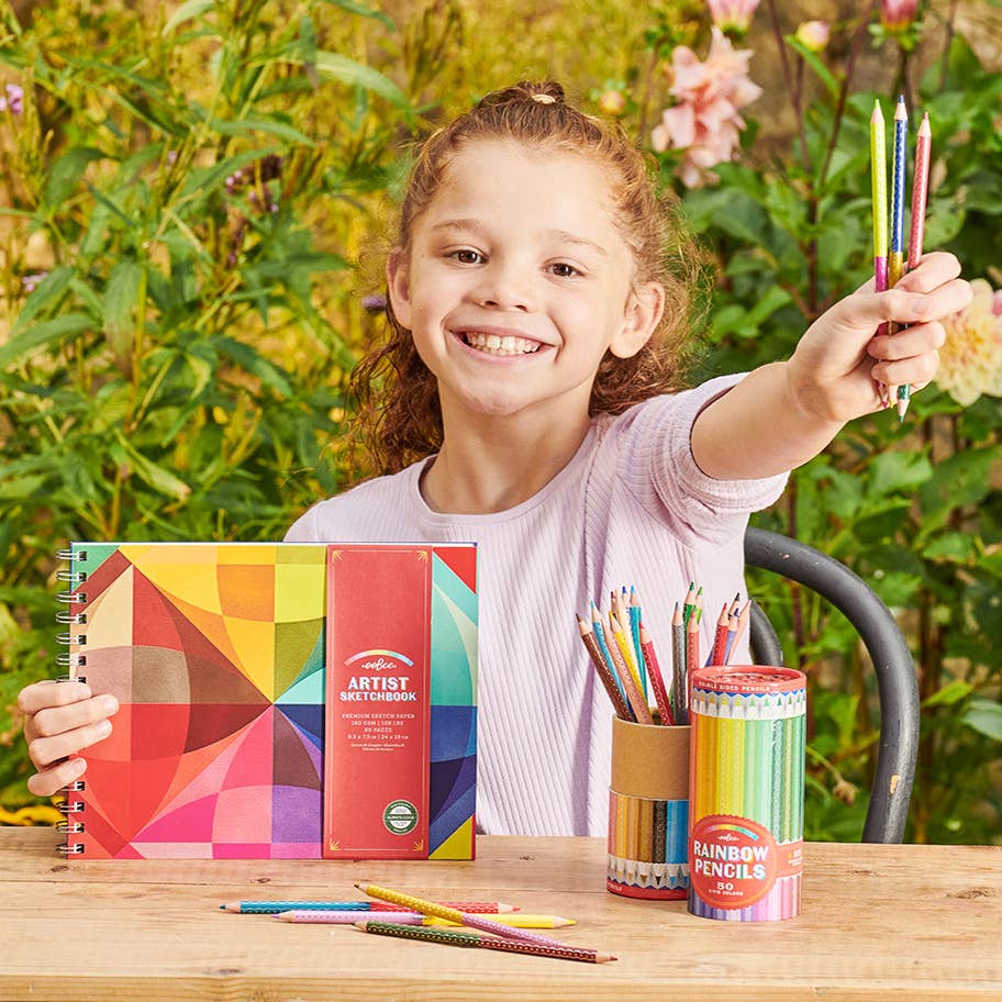 Young girl holding a colorful art supply set outdoors