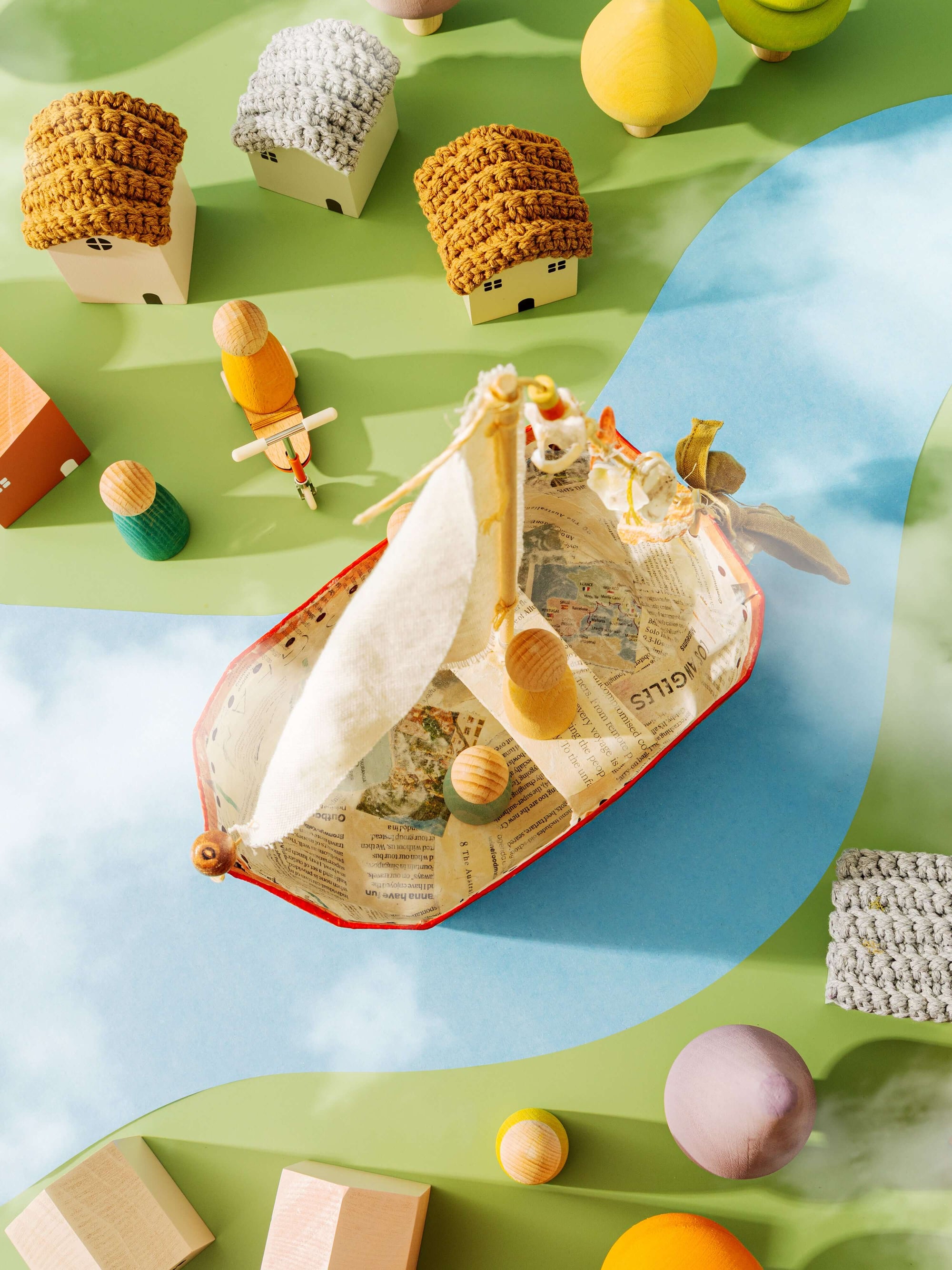 Children's toys including a boat, houses, and figurines on a colorful surface