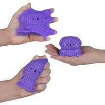 Purple knitted monsters held by hands against a neutral background