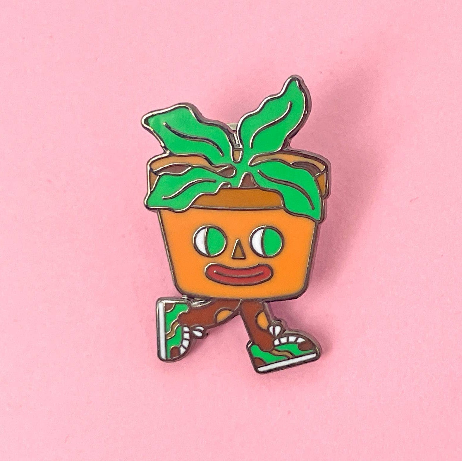 Pin with a cartoon-style potted plant character on a pink background