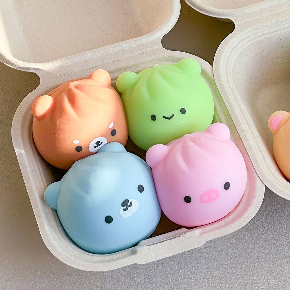 Four colorful bear-shaped squishies in a beige egg carton.