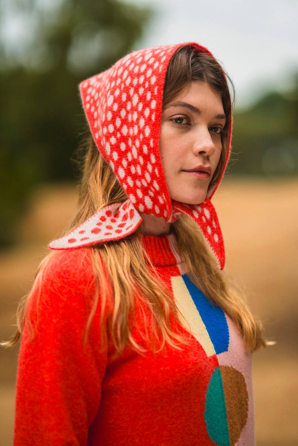 Person wearing a red patterned hood in an outdoor setting