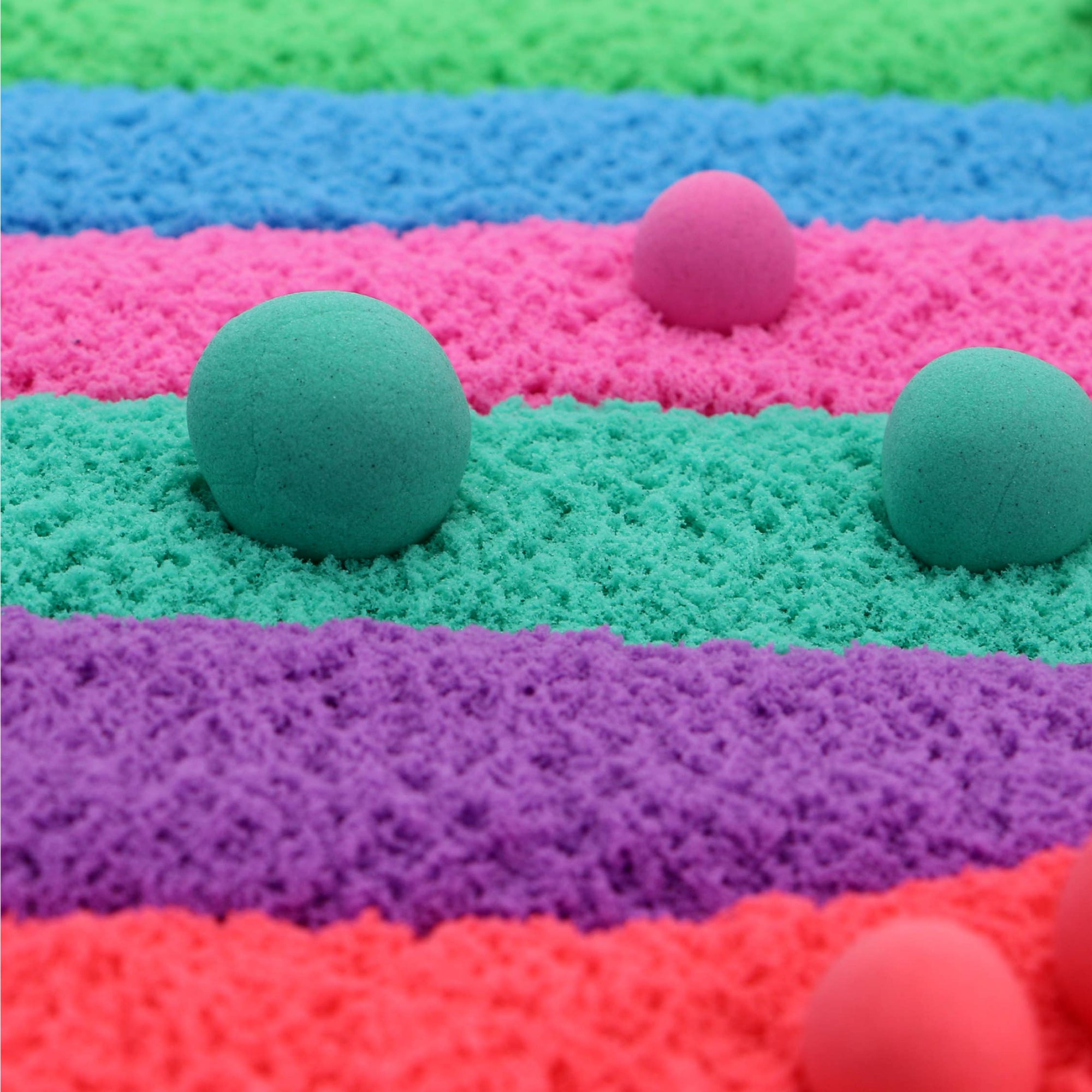Colorful sand with balls on a striped background