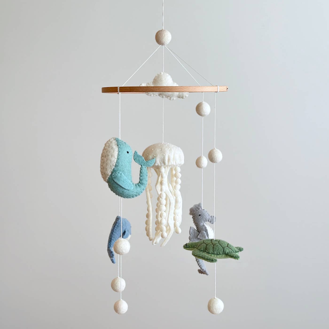 Children's mobile with whale, jellyfish, turtle, and fish on a white background