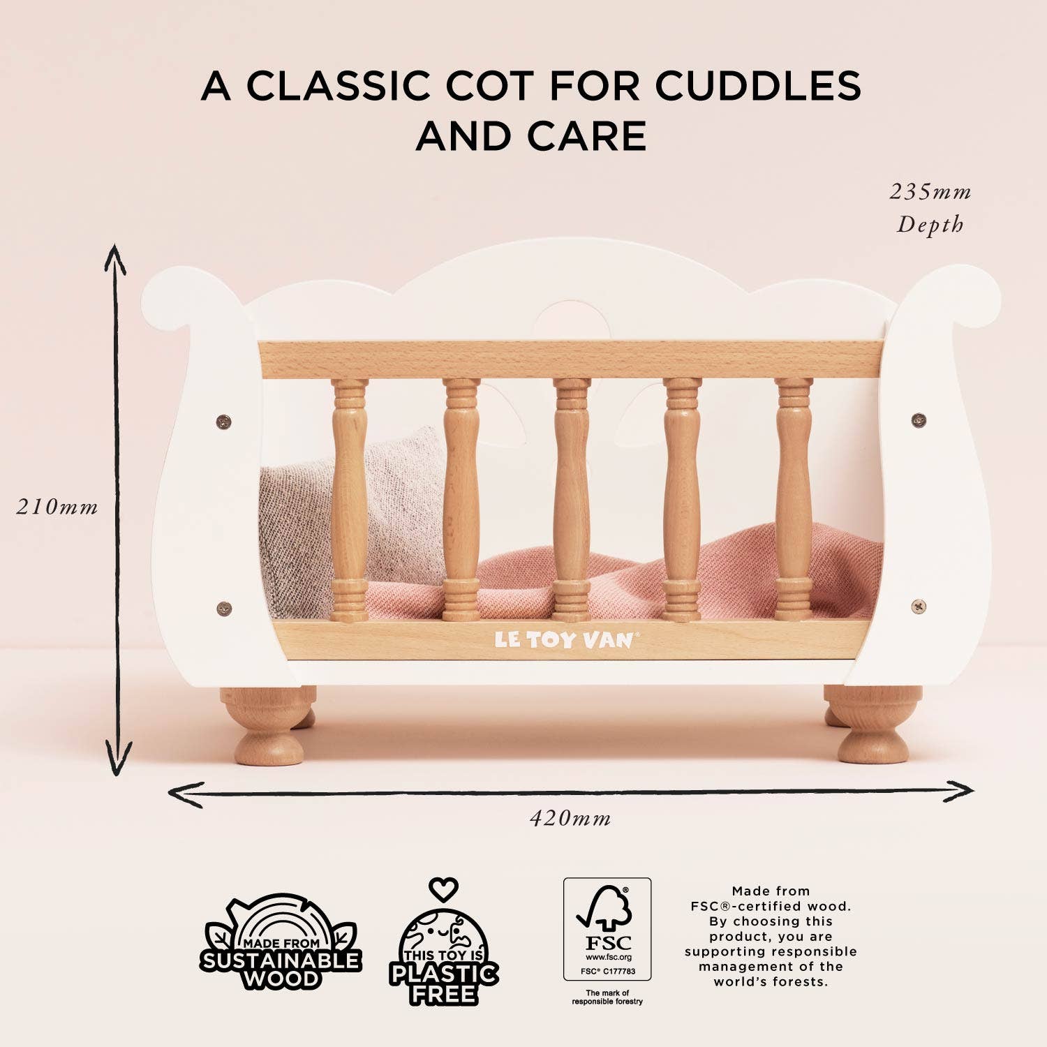 Wooden crib with dimensions and Le Toy Van branding on a light pink background