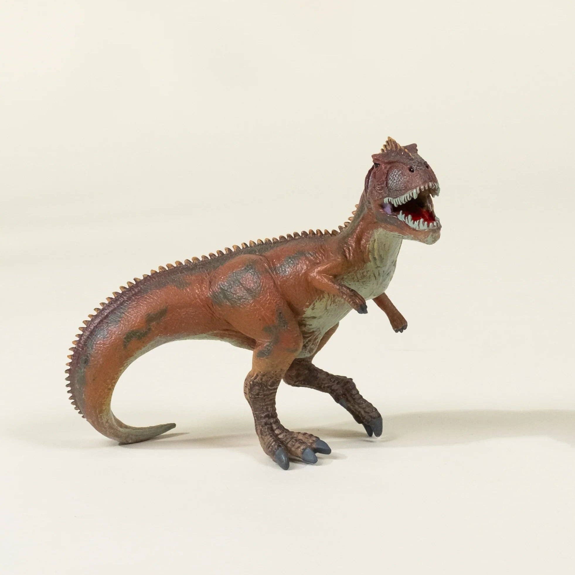 Dinosaur toy figure on a beige background