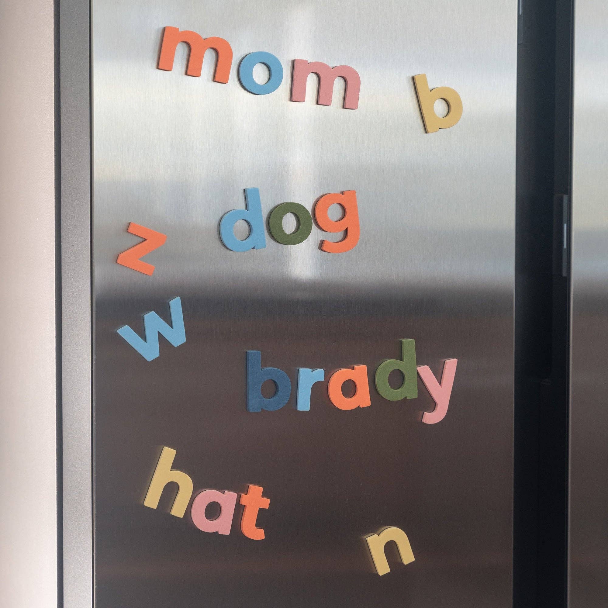 Frosted glass door with colorful magnetic letters spelling out names.