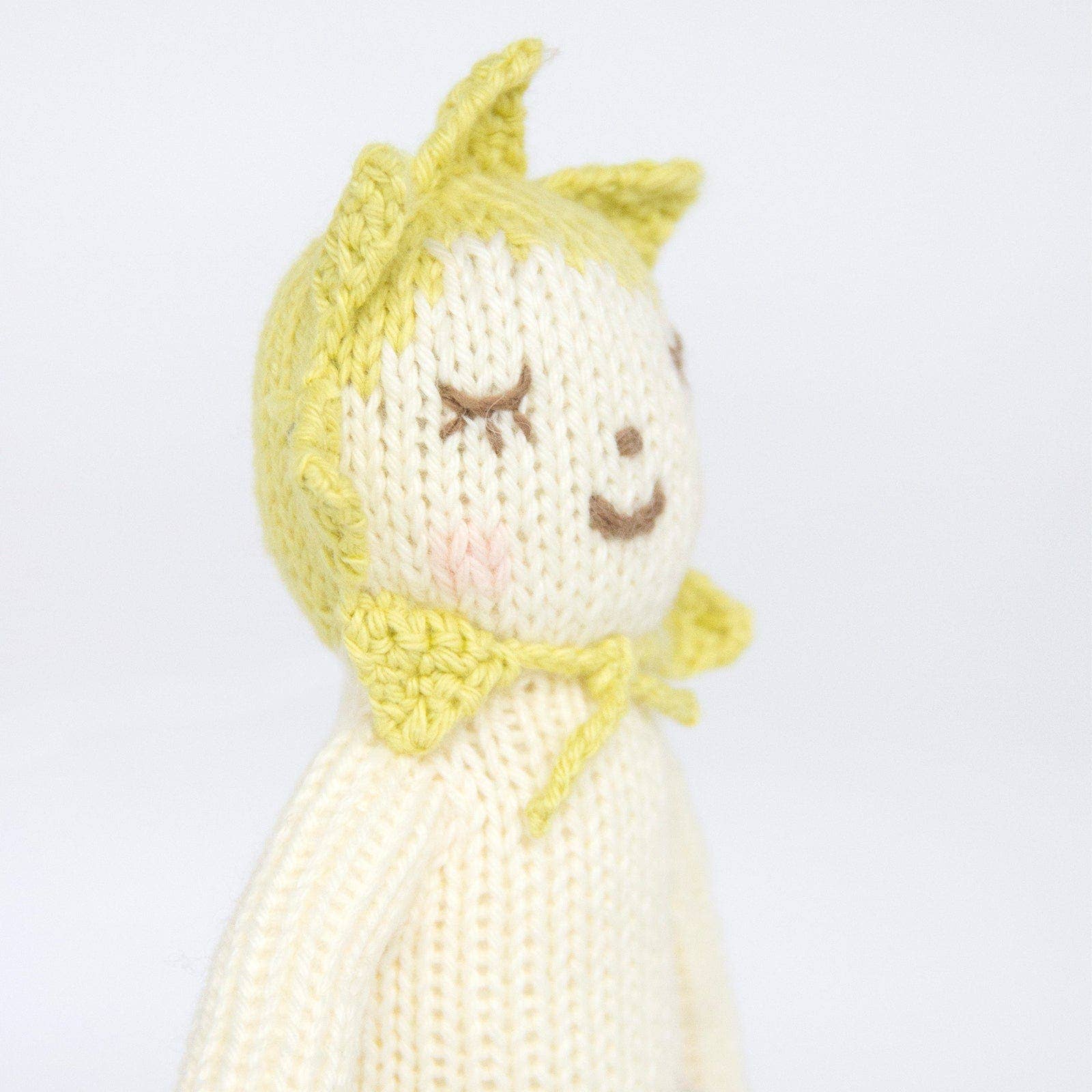 Knitted toy with yellow hair and dress on a white background