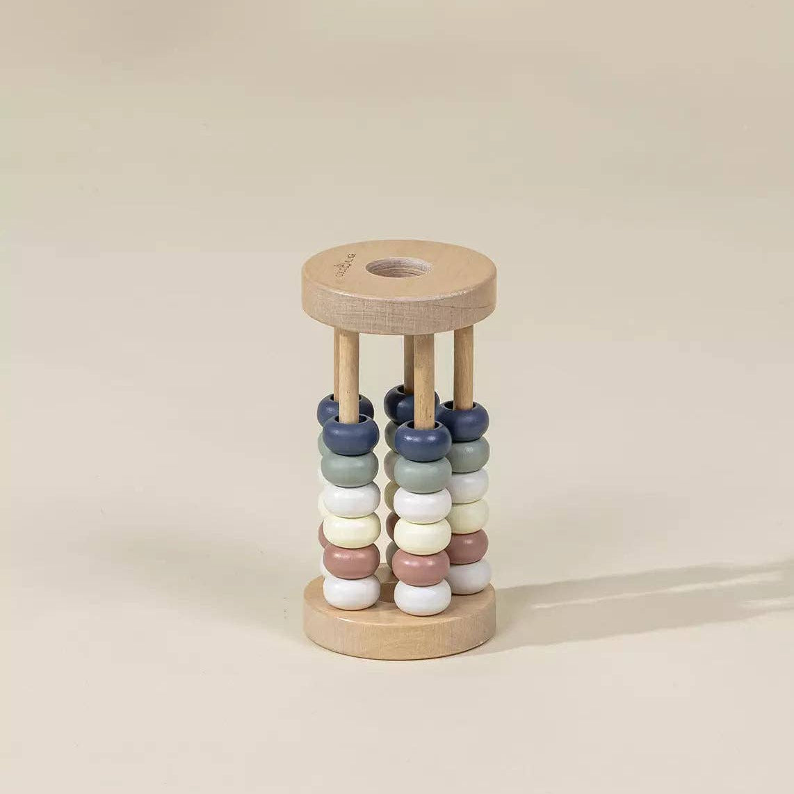 Wooden baby rattle with colorful beads on a beige background
