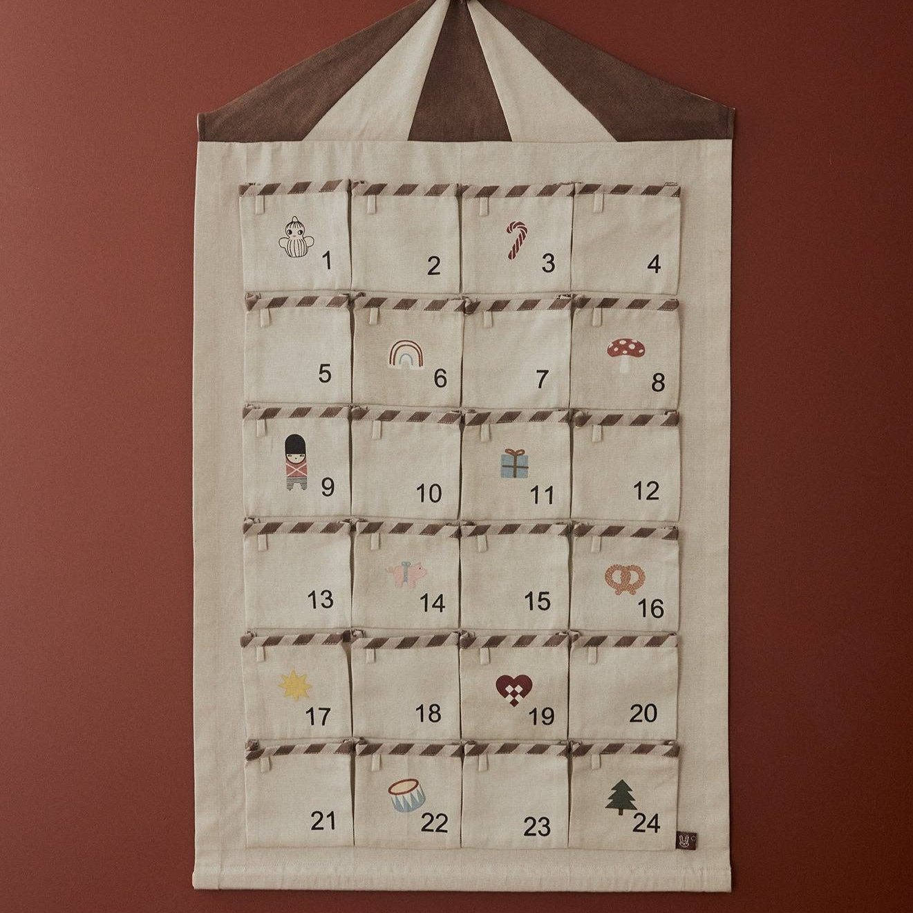 Fabric advent calendar with embroidered numbers and designs on a red background