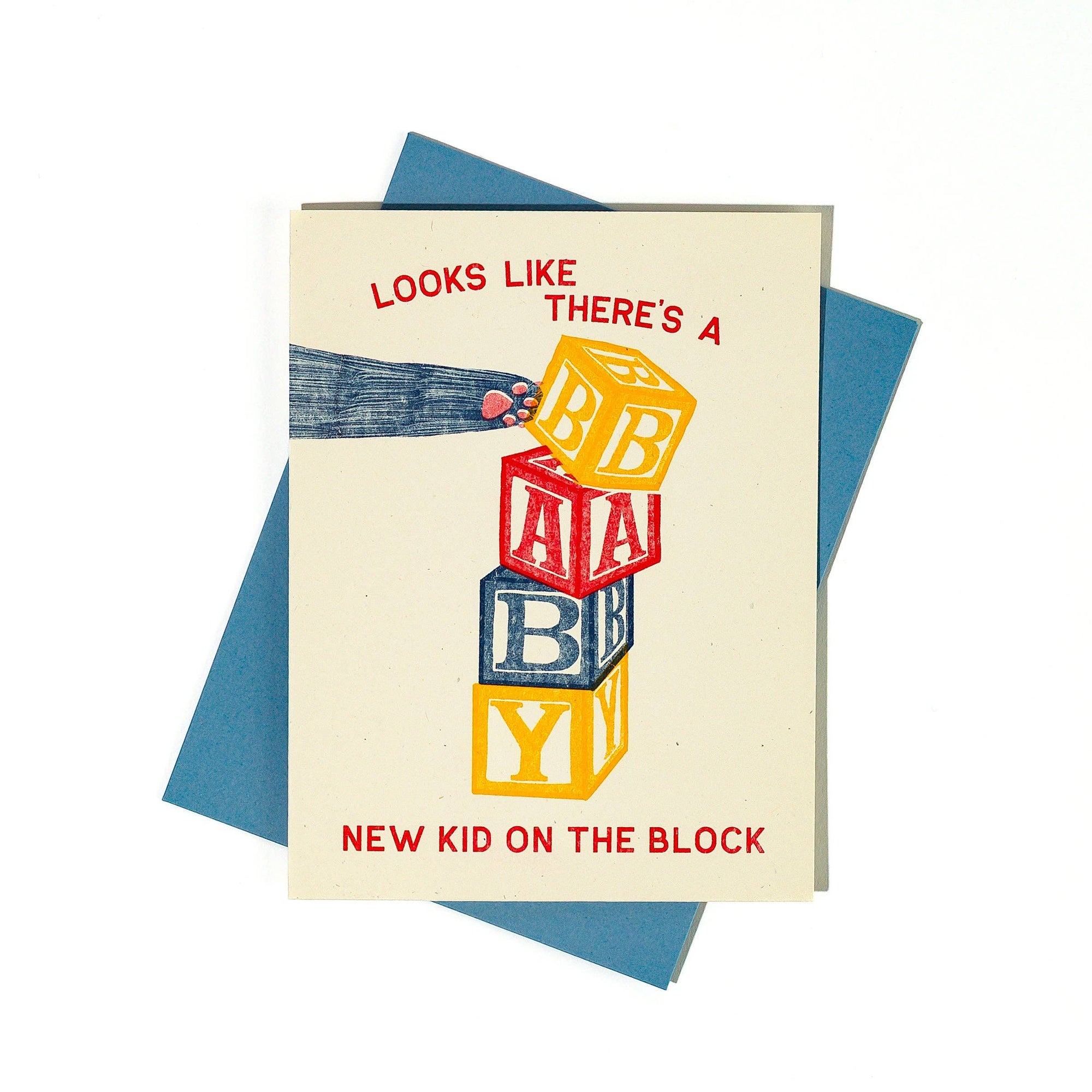 Greeting card with colorful baby blocks and text 'Looks like there's a baby new kid on the block' on a blue envelope.