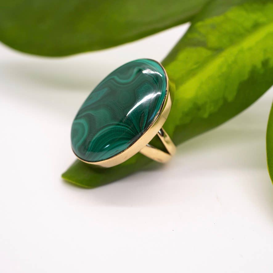 Ring with a green marbled stone on a green leaf