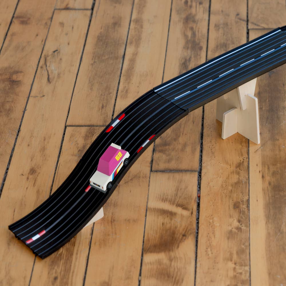 Toy car on a black track on a wooden floor