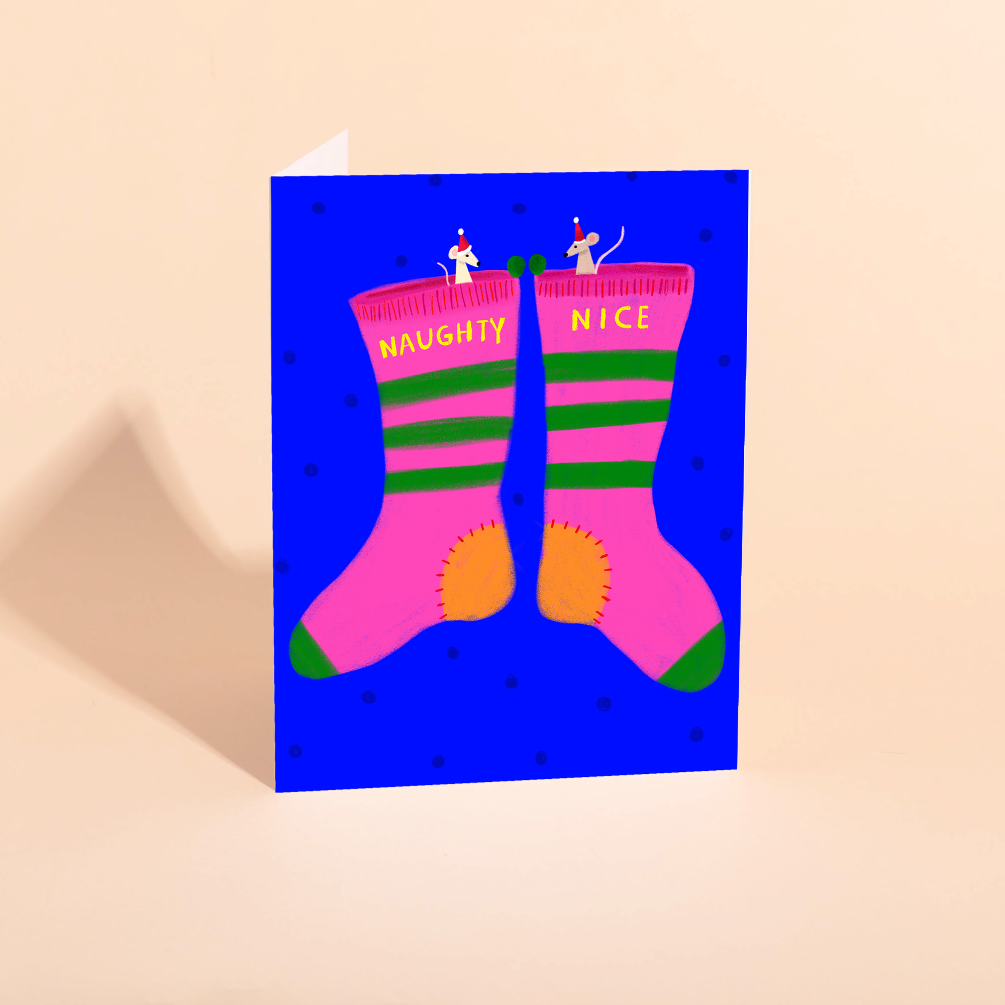 Greeting card with pink socks labeled 'Naughty' and 'Nice' on a blue background.