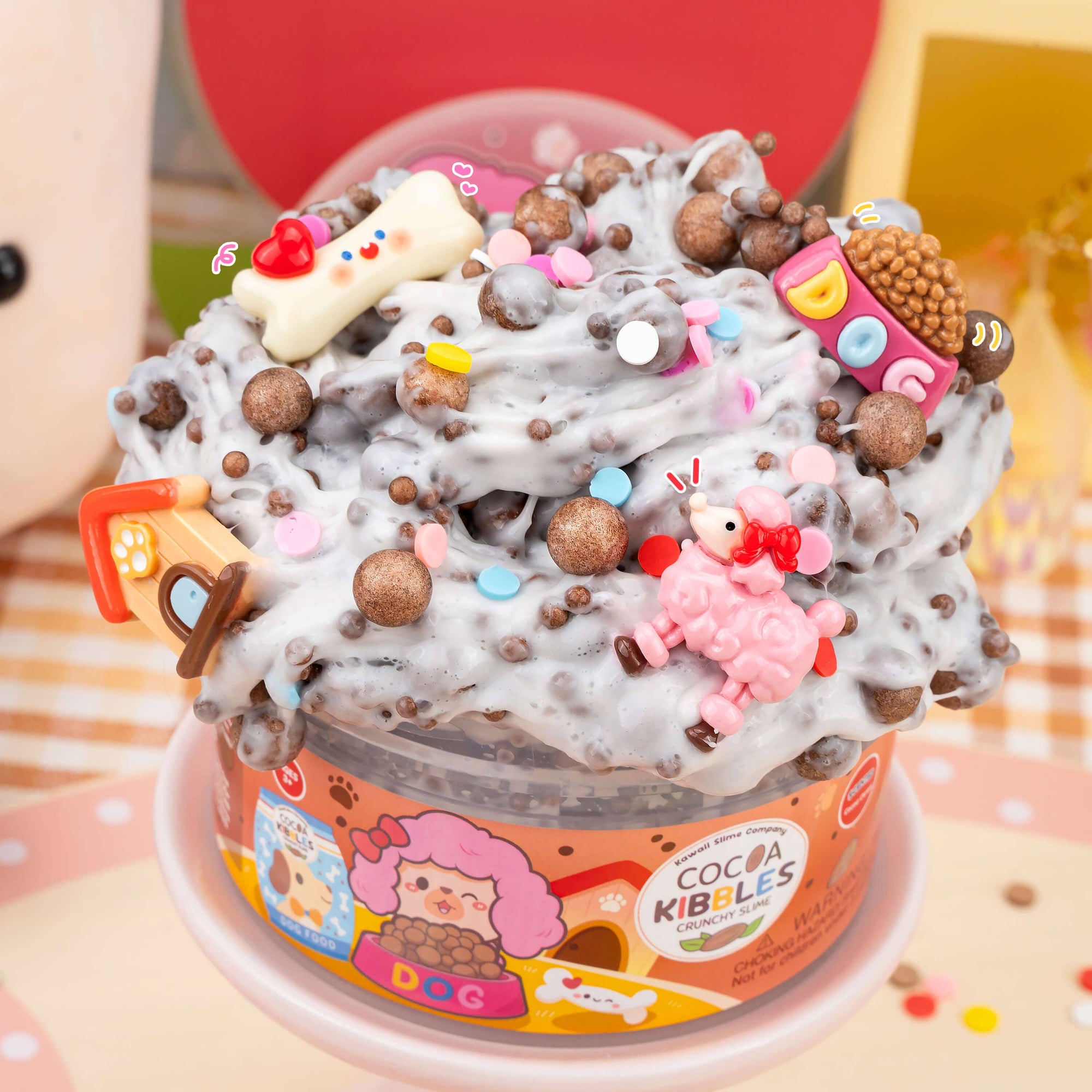 slime cup with colorful toppings and a visible brand label on a patterned background