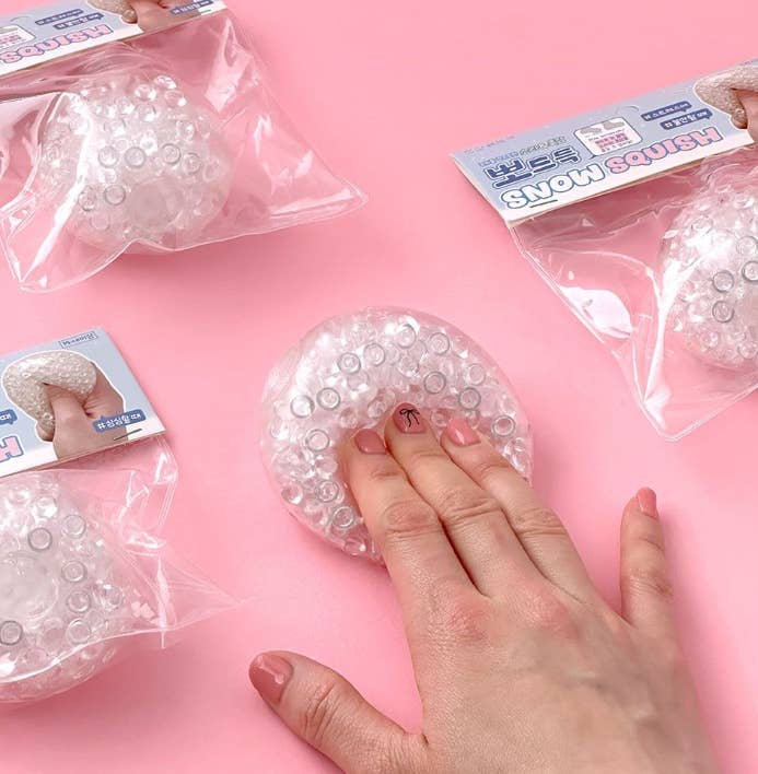 Clear silicone gloves with packaging on a pink background