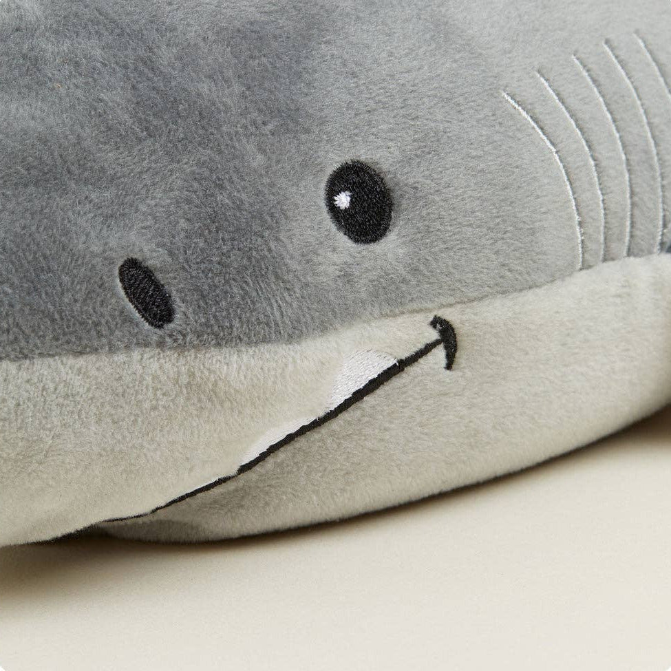 Plush shark toy with a simple face on a light background