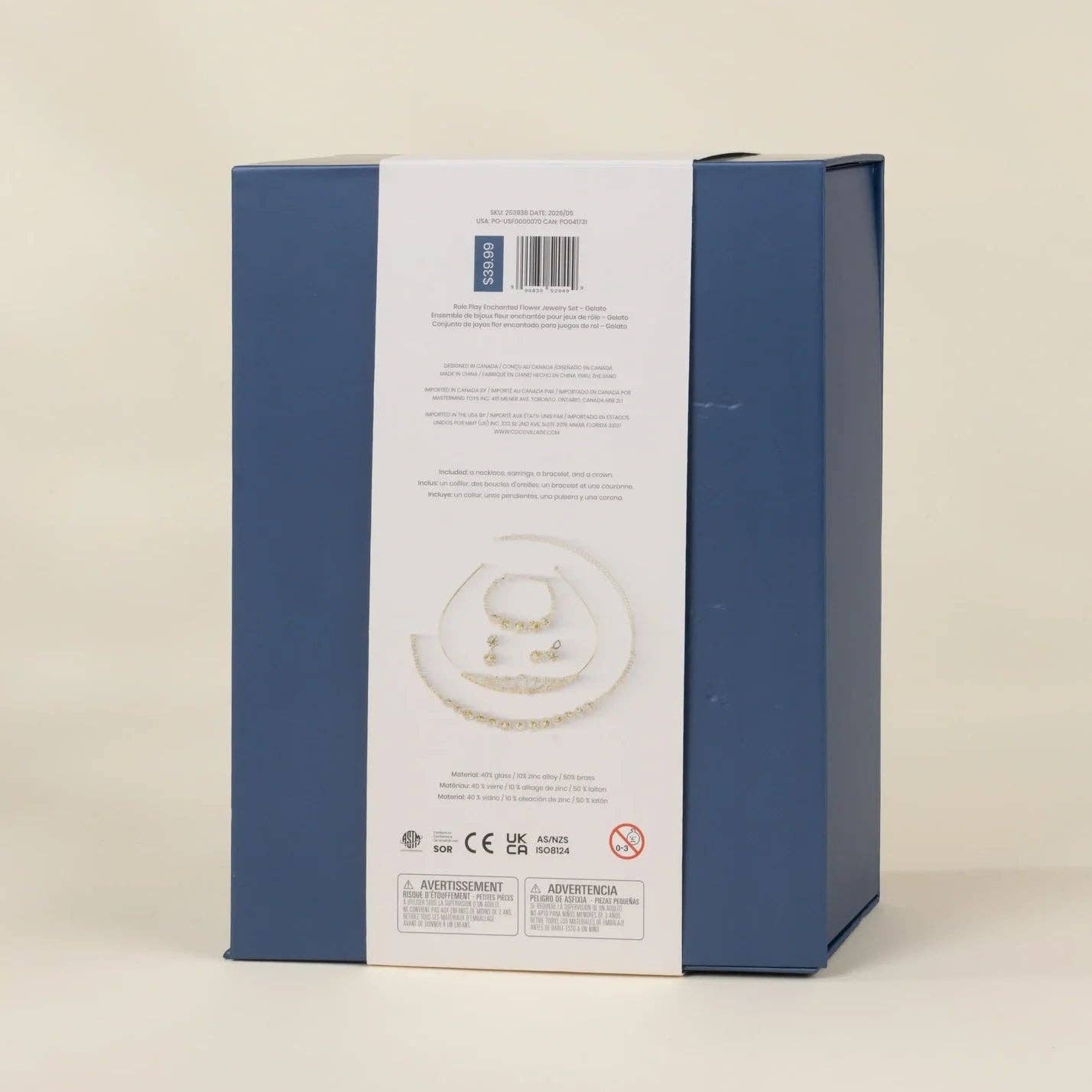 The back of a blue jewelry gift box with a white paper band, photographed against a solid light beige background.