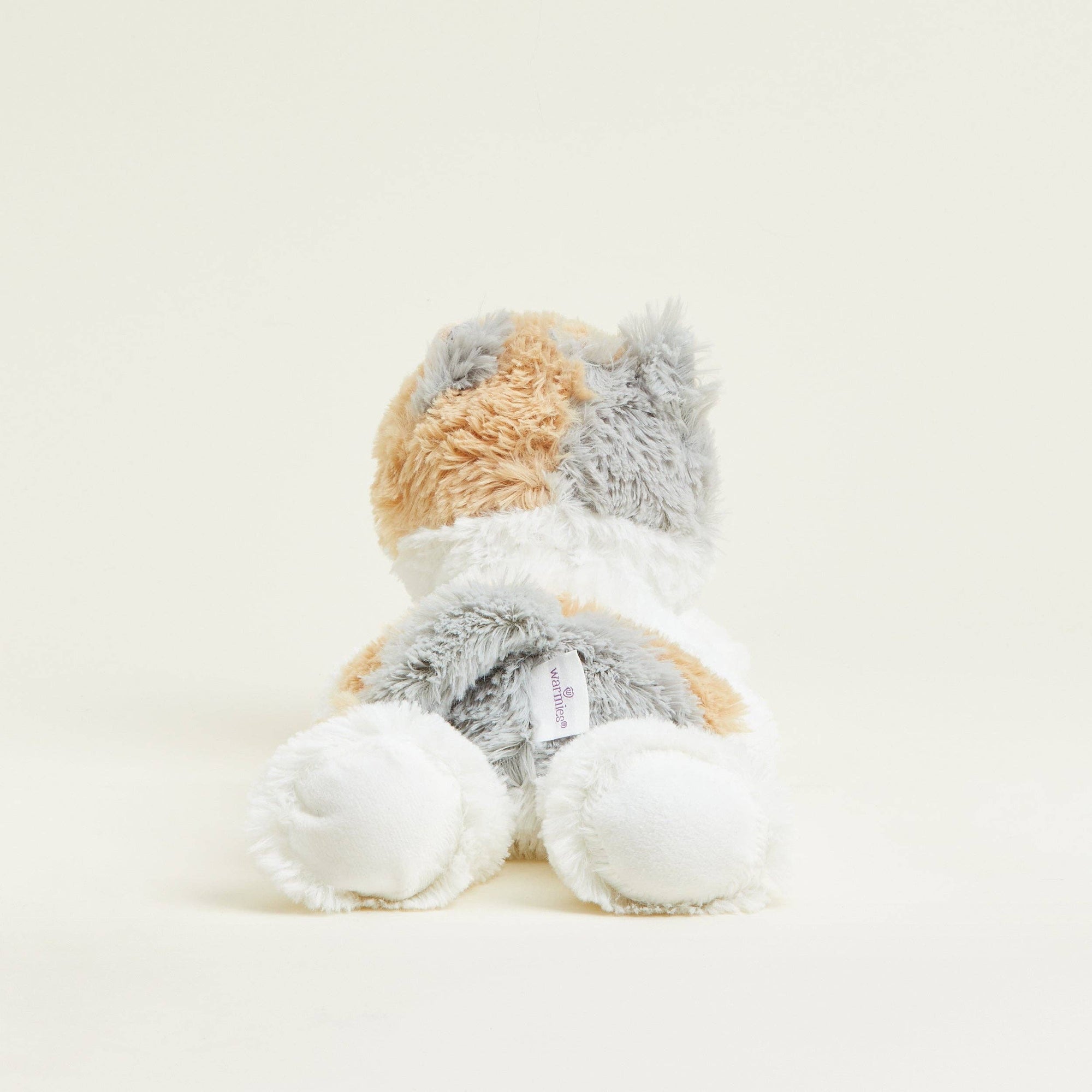 Plush toy resembling a cat with a white, gray, and orange color scheme on a light beige background.