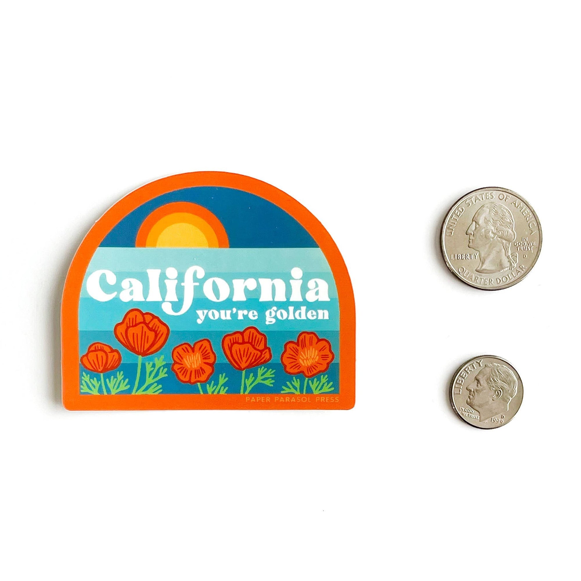 Colorful 'California you're golden' sticker with two coins for size comparison on a white background