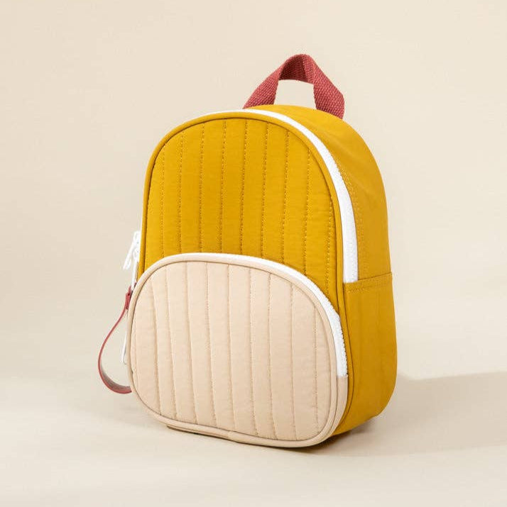 Yellow and beige quilted backpack on a beige background