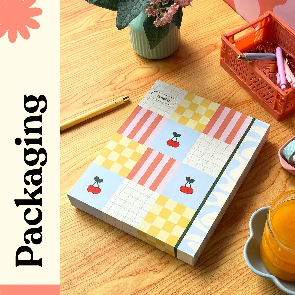 Notebook with colorful design on a wooden table with stationery items.