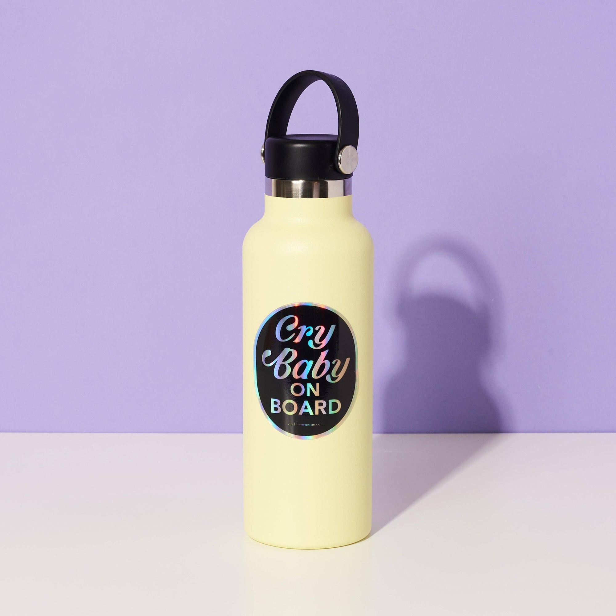 Yellow water bottle with 'Cry Baby on Board' sticker on a purple background