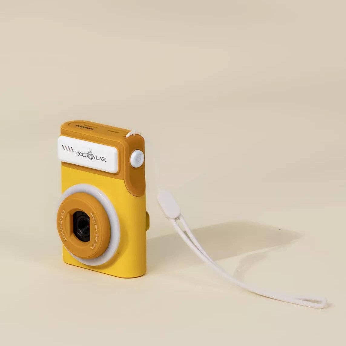 Yellow toy camera with a white strap on a beige background
