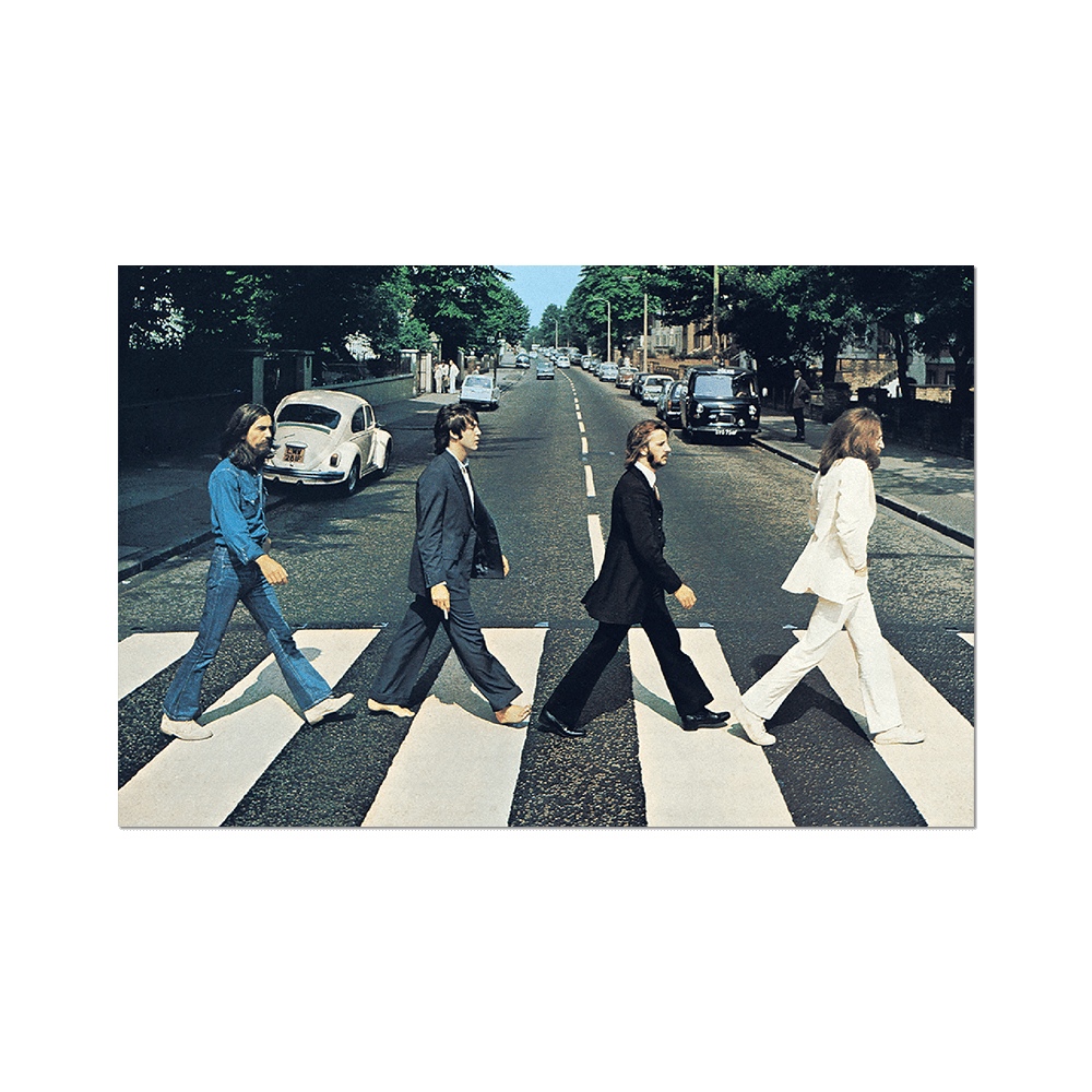 The Beatles crossing the zebra crossing in Abbey Road with vintage cars and street scene in the background.