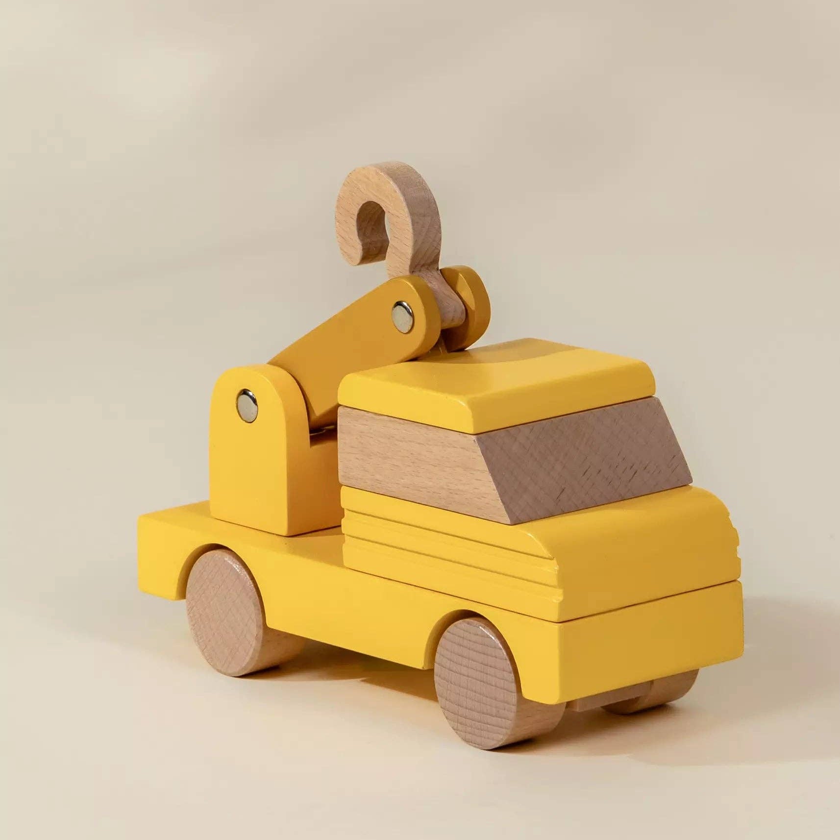 Wooden toy truck with a crane on a beige background