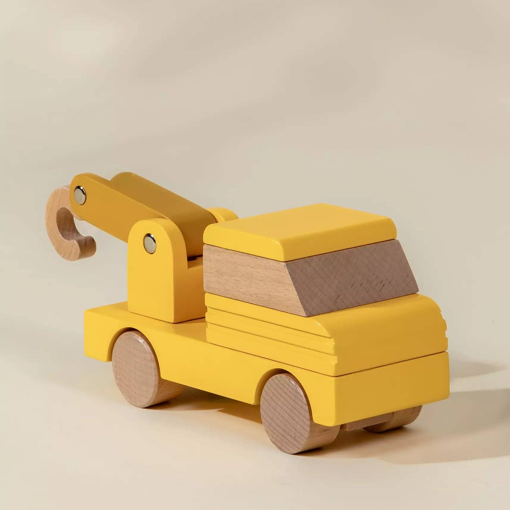 Yellow toy crane on a beige background