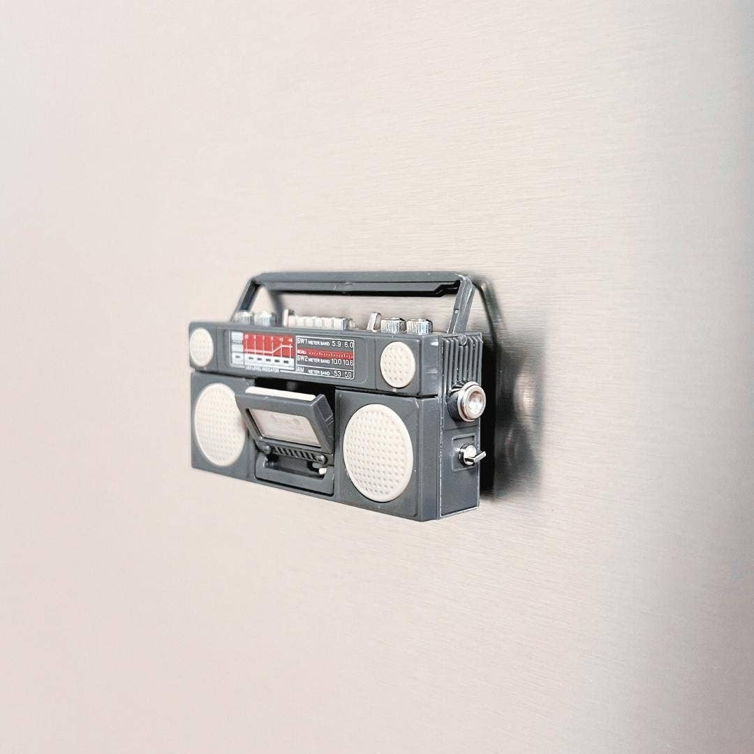 Vintage-style gray boombox on a light beige background