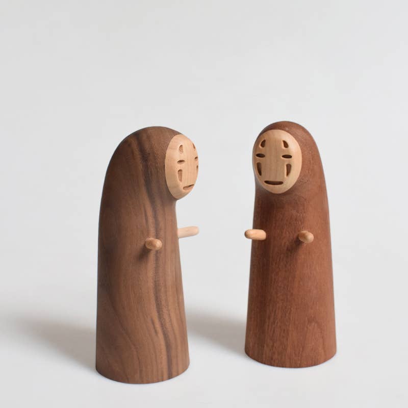 Two wooden figures with minimalistic faces on a light gray background