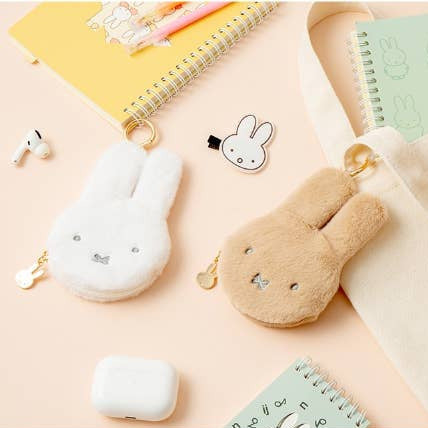 Kawaii-themed pouches and keychains on a light pink background