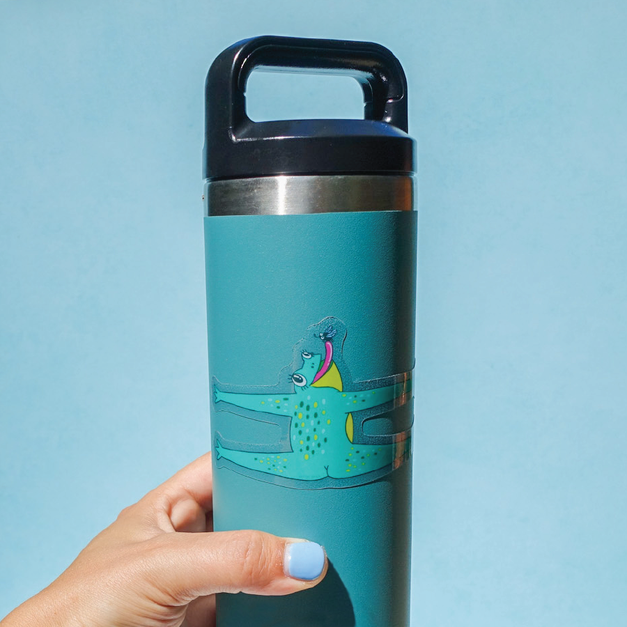 Turquoise water bottle with a handle held by a hand against a light blue background