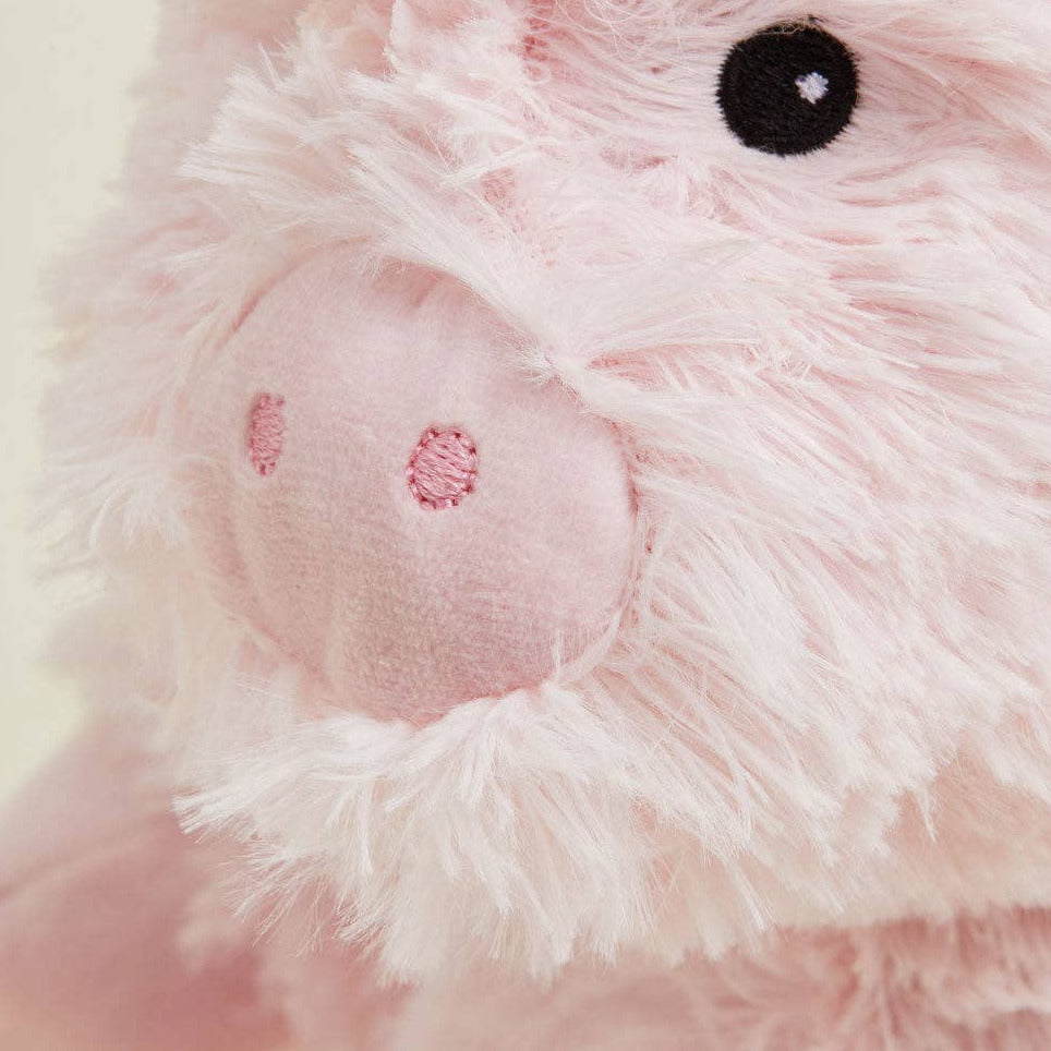 Close-up of a pink plush toy with white accents on a light background