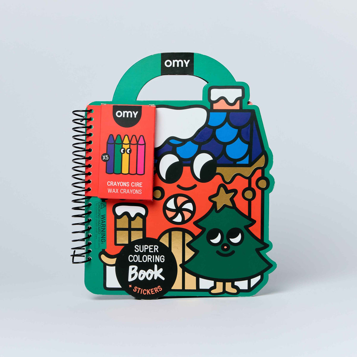 Omy Super Coloring Book Christmas Edition with a spiral-bound page and colorful cartoon illustrations, including a house, tree, and crayons, shown on a light gray background.