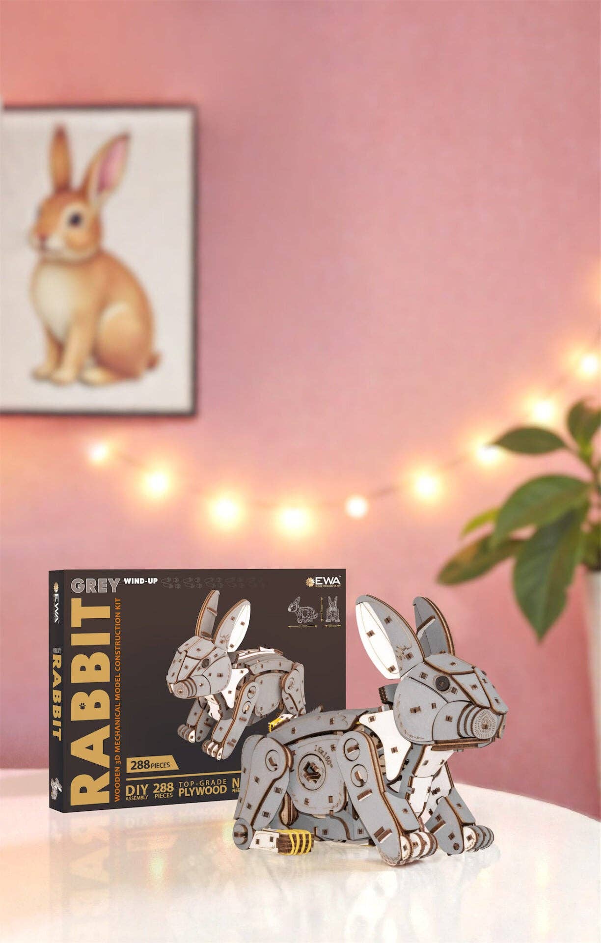 Wooden rabbit puzzle with packaging on a surface with a pink wall and decorative lights in the background.