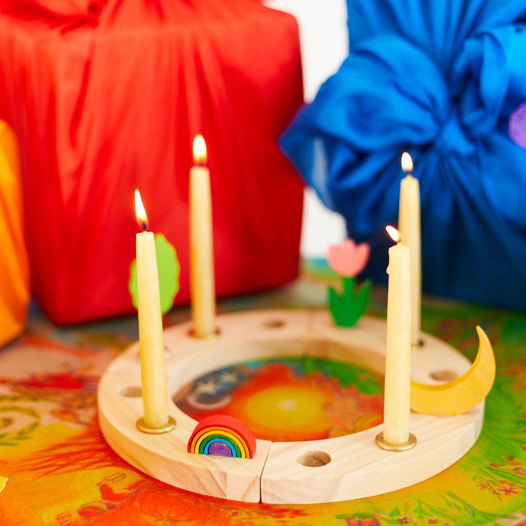 Wooden candle holder with lit candles on a colorful surface