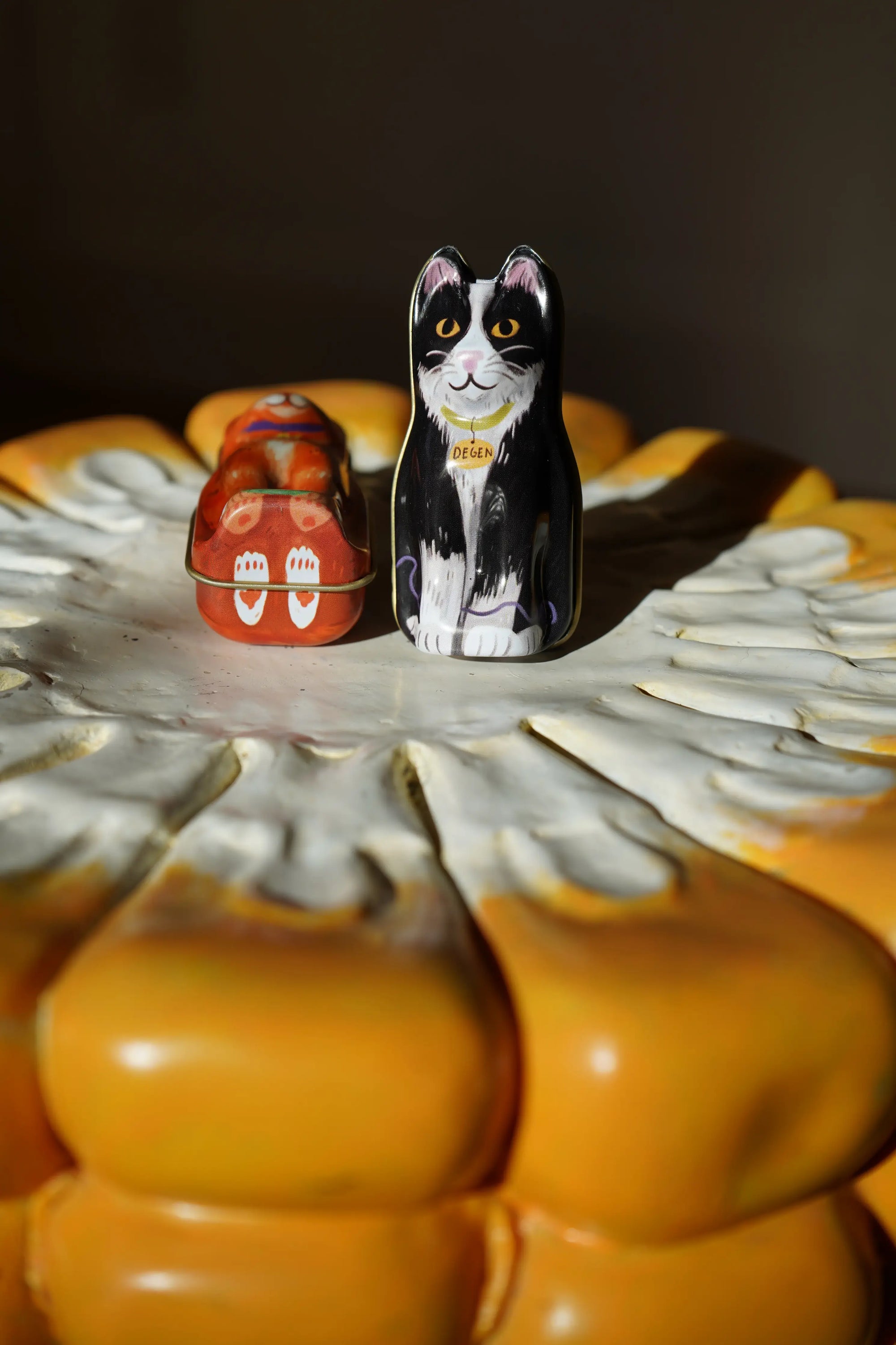 Decorative salt and pepper shakers shaped like a black and white cat on a sunflower-shaped stand.