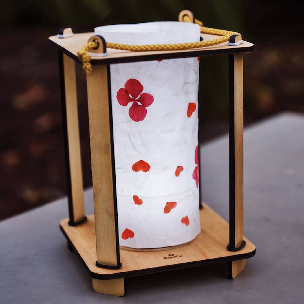 Wooden lantern with floral design on a white paper towel roll