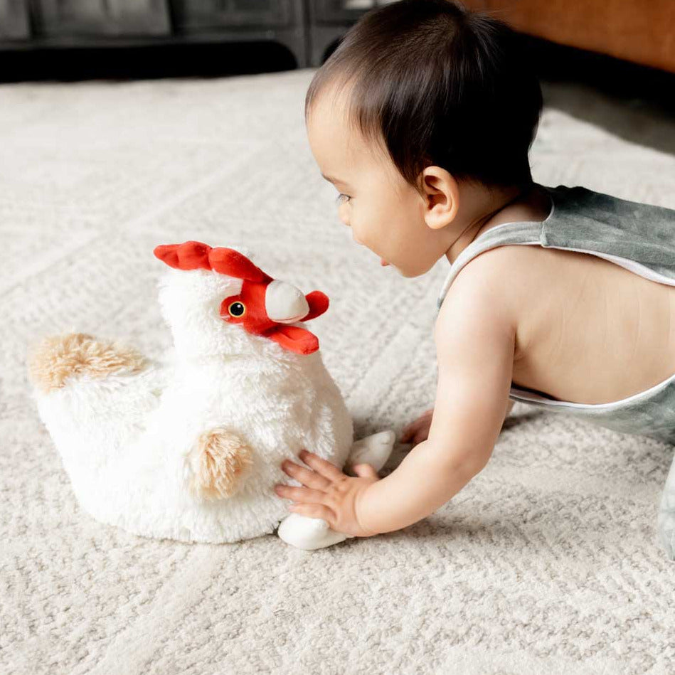 Baby playing with a plush toy on a carpeted floor
