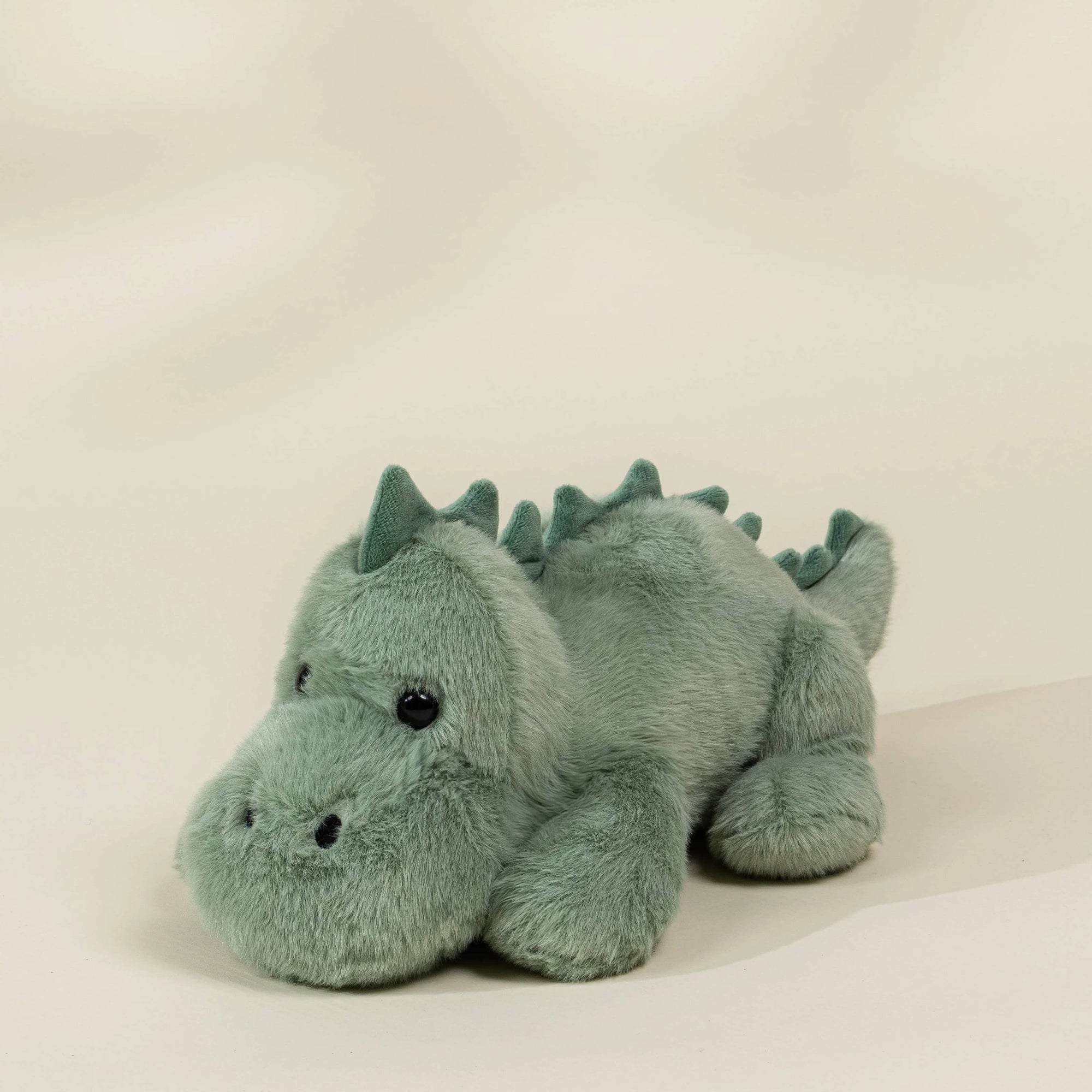 Plush dragon toy on a beige background