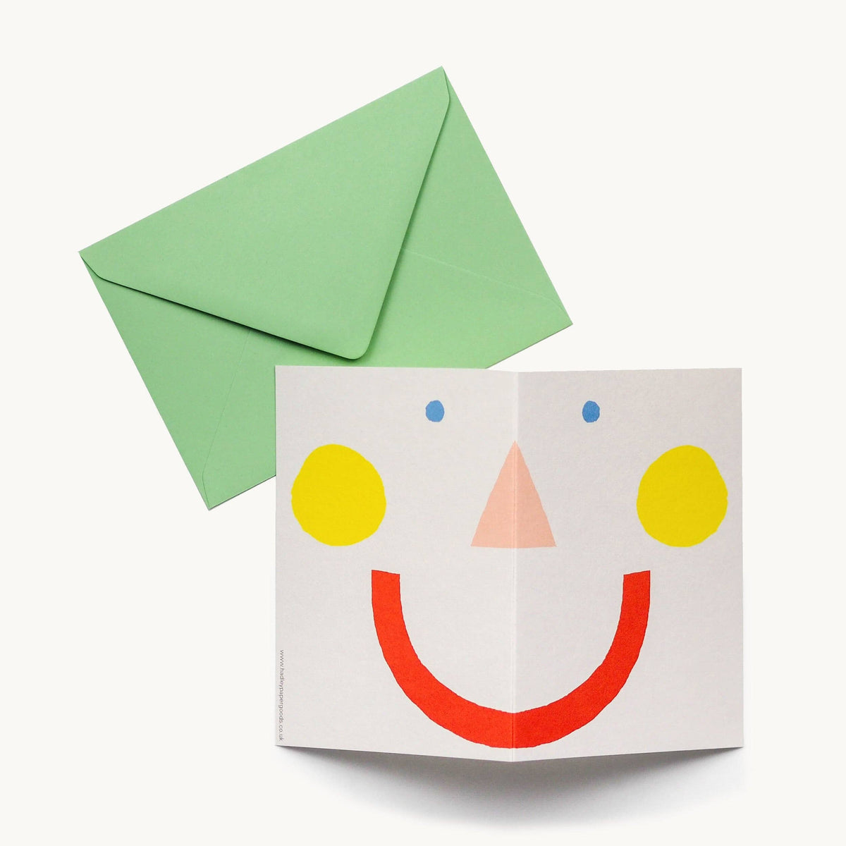 Card with a smiley face design and a green envelope on a white background