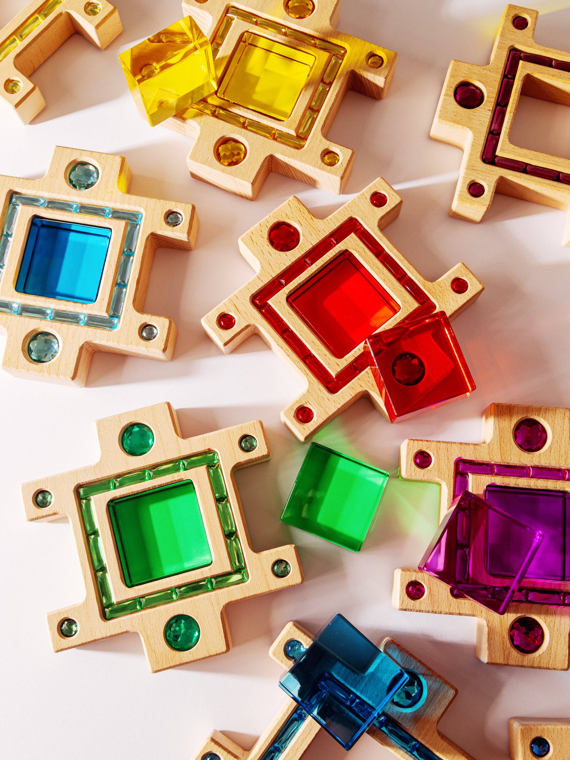 Colorful square-shaped beads with gold frames on a light background