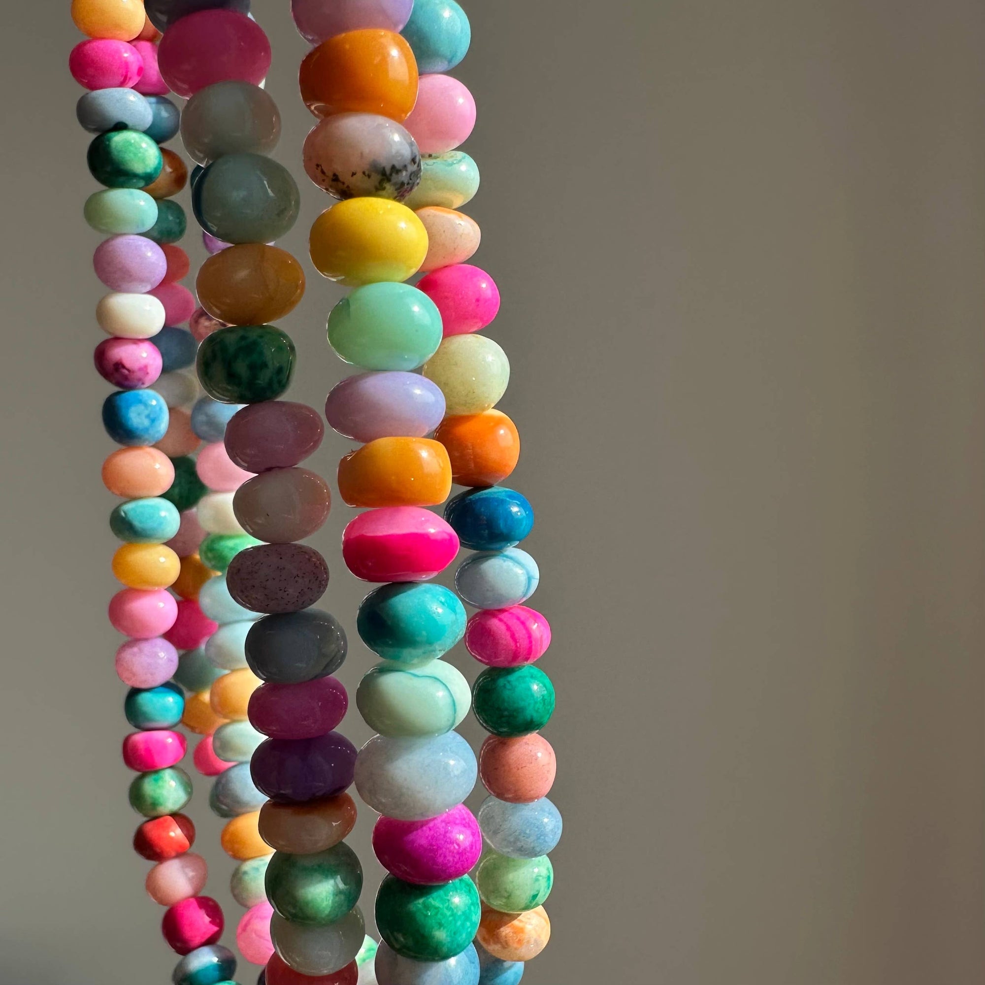Colorful beaded necklaces on a neutral background